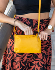 Person holding a yellow purse with a blurred background