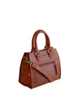 Chestnut leather handbag with brass accents on a white background