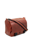 Brown leather bag with a black strap on a white background