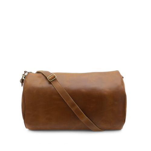 Brown leather duffel bag with a strap on a white background