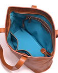 Brown leather bag with blue interior on a white background