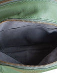 Green leather bag with open zipper showing black interior