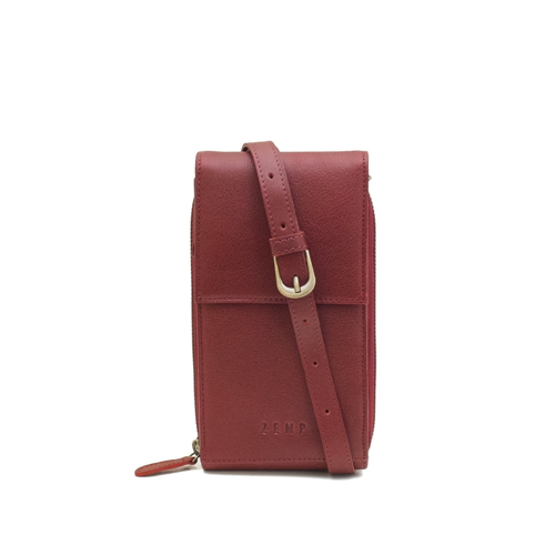 Red leather crossbody bag with a strap on a white background