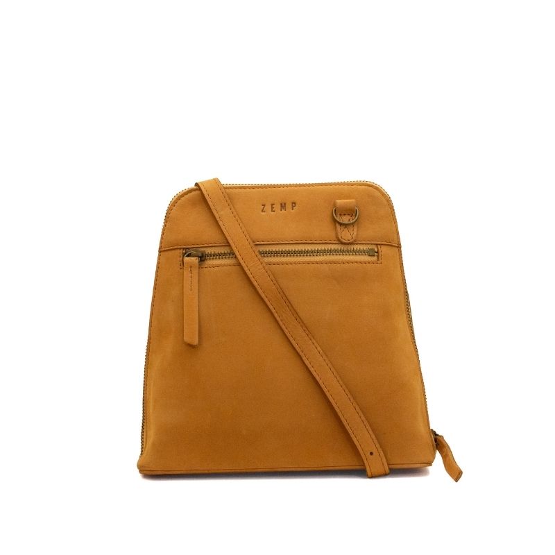 A mustard yellow suede crossbody bag with a top zipper, front zip pocket, and a diagonal shoulder strap, featuring the brand name 'ZEMP' on the front, set against a plain white background.