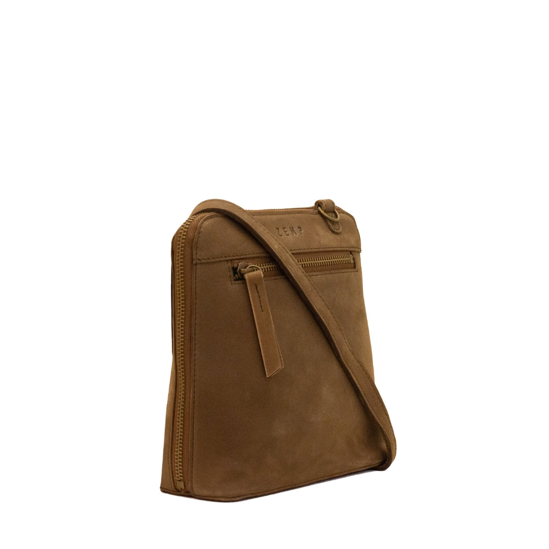 A brown leather crossbody bag with a matching adjustable shoulder strap, shown from a three-quarter angle against a plain white background.