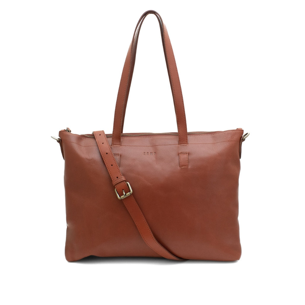 Brown leather tote bag with a shoulder strap on a white background