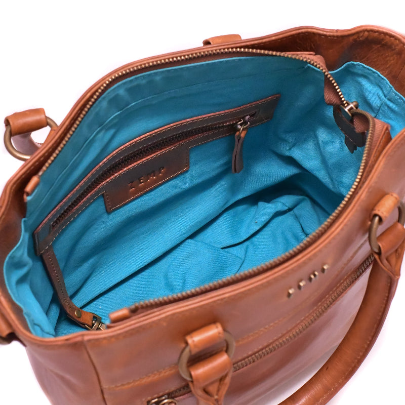 Brown leather handbag with blue interior on a white background