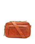 A warm chestnut leather crossbody bag with a matching leather shoulder strap, gold-tone hardware, and a front zippered pocket, shown on a plain white background.