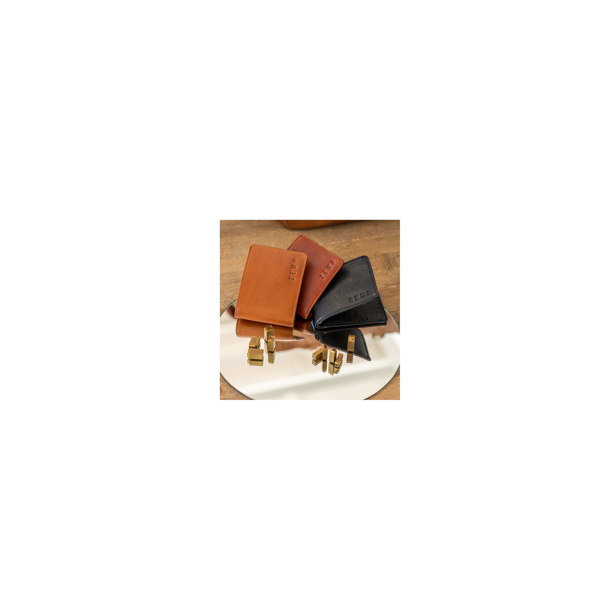 Three leather wallets in brown, black, and tan on a reflective surface with 'Zerm' branding.