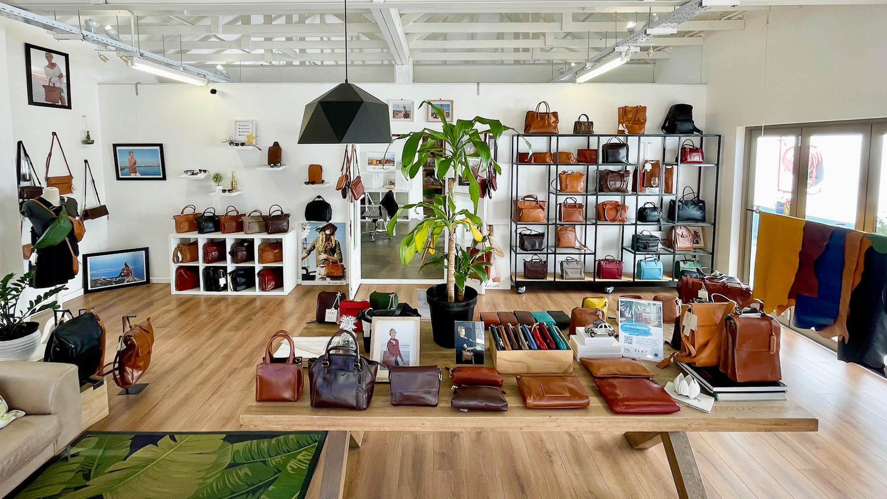 Display of handbags and accessories in a store with shelves and decor.