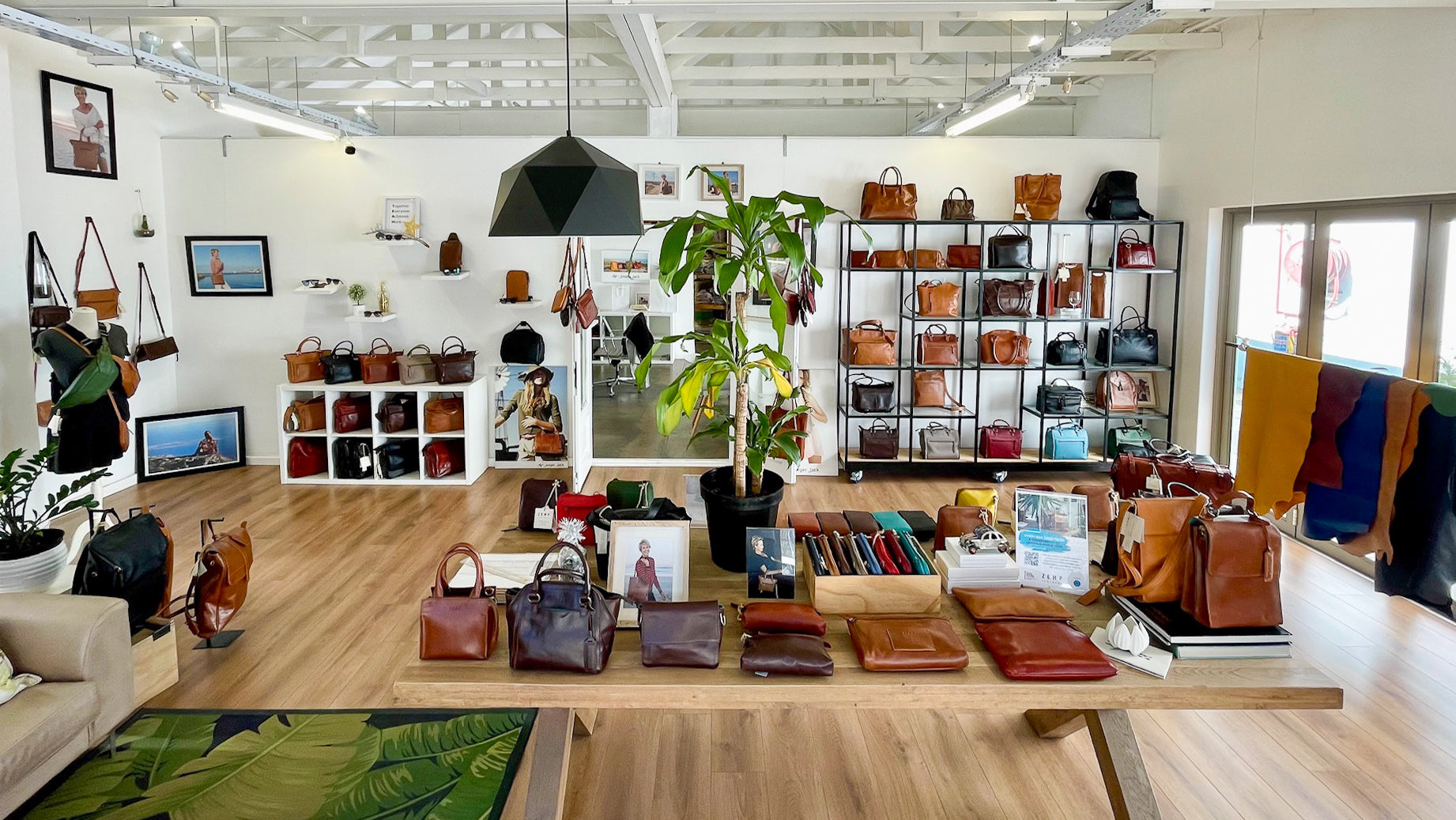 Display of handbags and accessories in a store with shelves and decor.